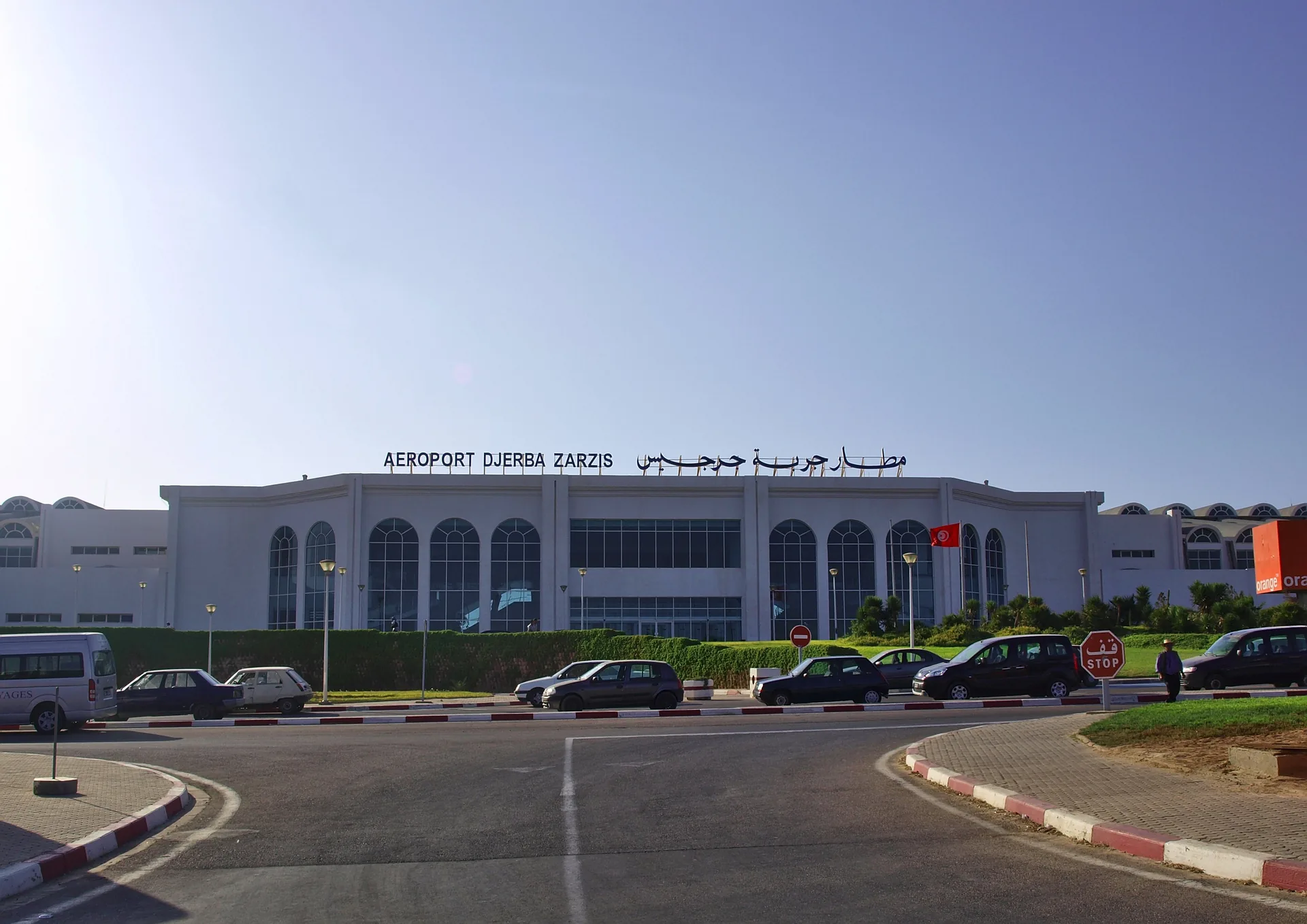 Terminal building facade of Djerba-Zarzis Airport, showing the terminal signage and visitor car park